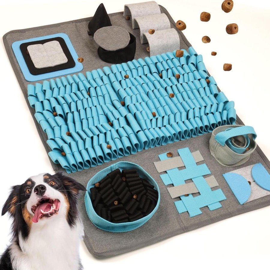 Alfombra olfativa PetGens gris y azul con tiras, cuencos y solapas para esconder premios, junto a un perro sonriente