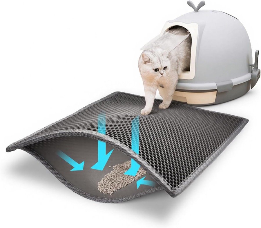 Gato saliendo de un arenero cerrado sobre la alfombrilla Pieviev gris, con flechas que muestran la arena cayendo entre las capas