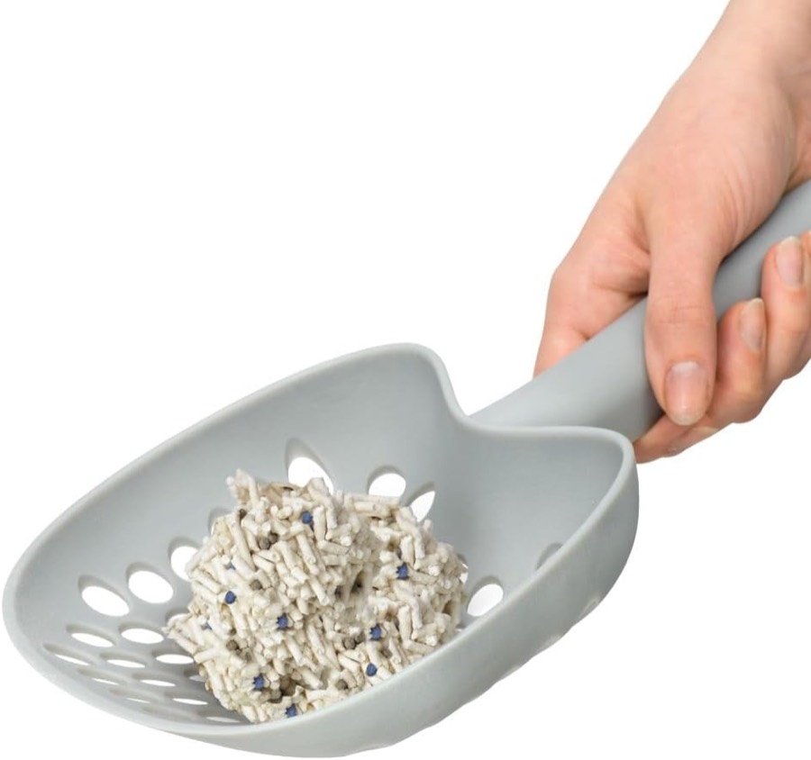 Ver imagen 4 de 6: Mano con una pala gris llena de pellets blancos de la arena Catit