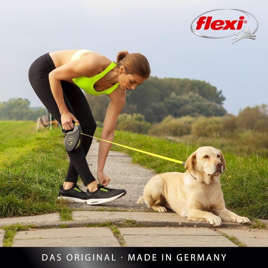Ver imagen 2 de 6: Mujer deportista recogiendo la correa flexi Giant junto a un labrador tumbado en un camino