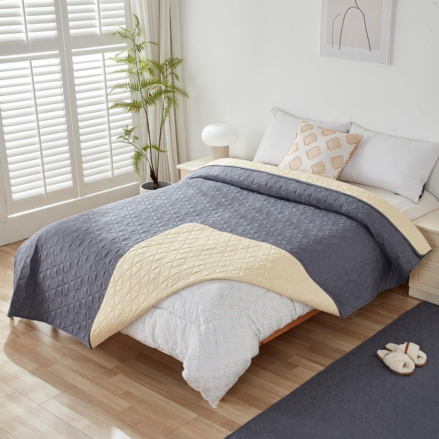 Ver imagen 5 de 6: La manta Taiyang sobre una cama, doblada para enseñar el reverso beige