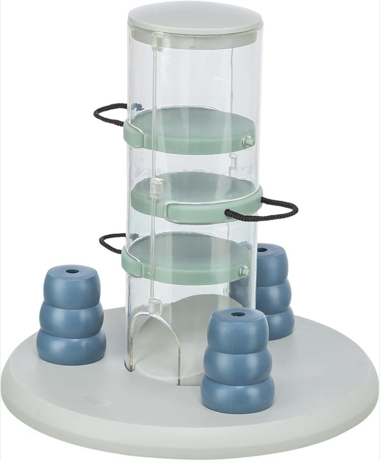 Trixie Gambling Tower: torre transparente con bandejas verdes y asas de cuerda sobre una base blanca con cuatro conos azules