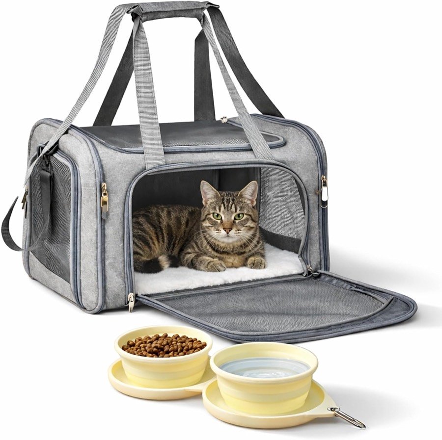 Gato atigrado tumbado en el transportín blando PAW PANACHE gris con la puerta frontal abierta y el cuenco doble plegable amarillo delante